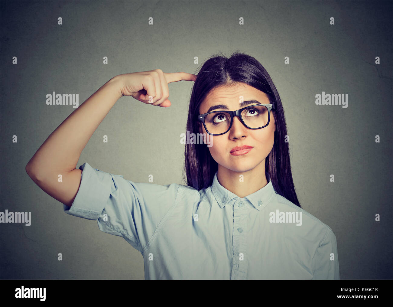 Denken ratlos Frau suchen isoliert auf grauen Hintergrund. nachdenklich Mädchen kratzen Kopf Lösen eines Problems Stockfoto