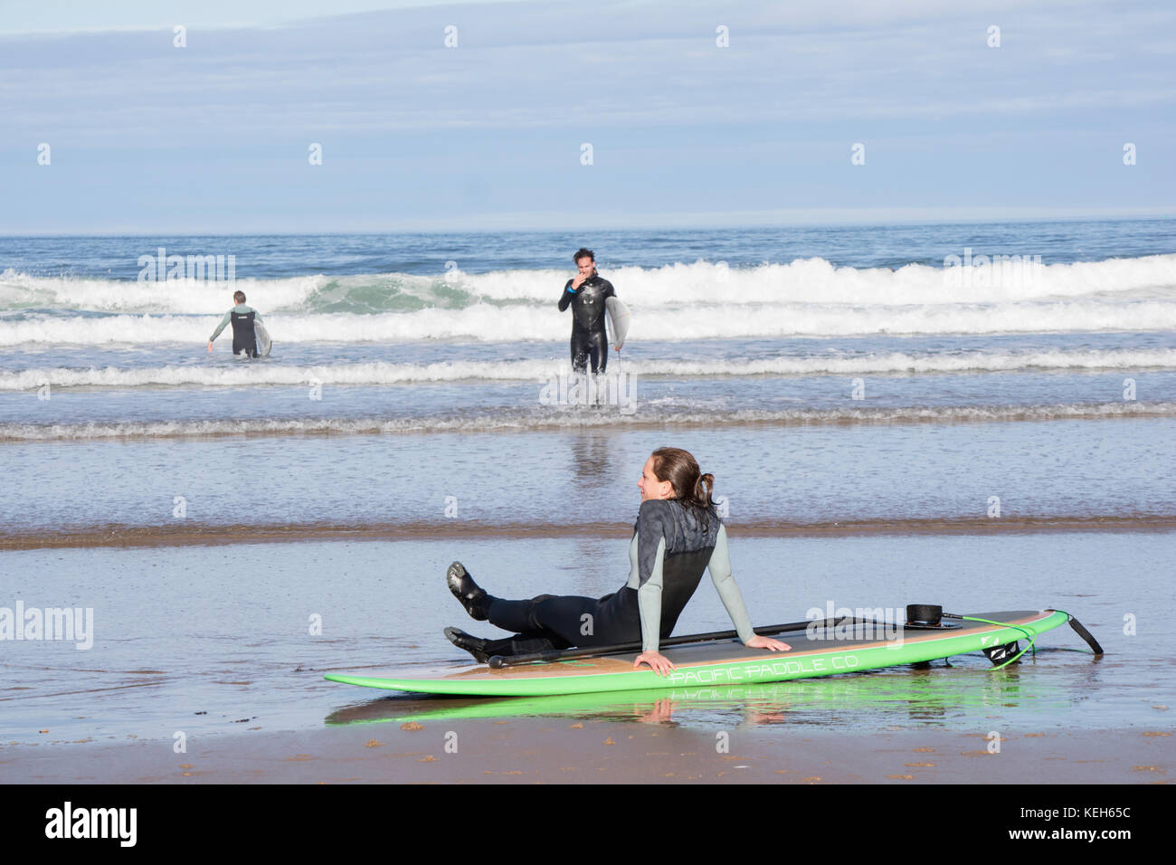 Surfen auf Bamburgh Beach, Northumberland, England, Großbritannien Stockfoto