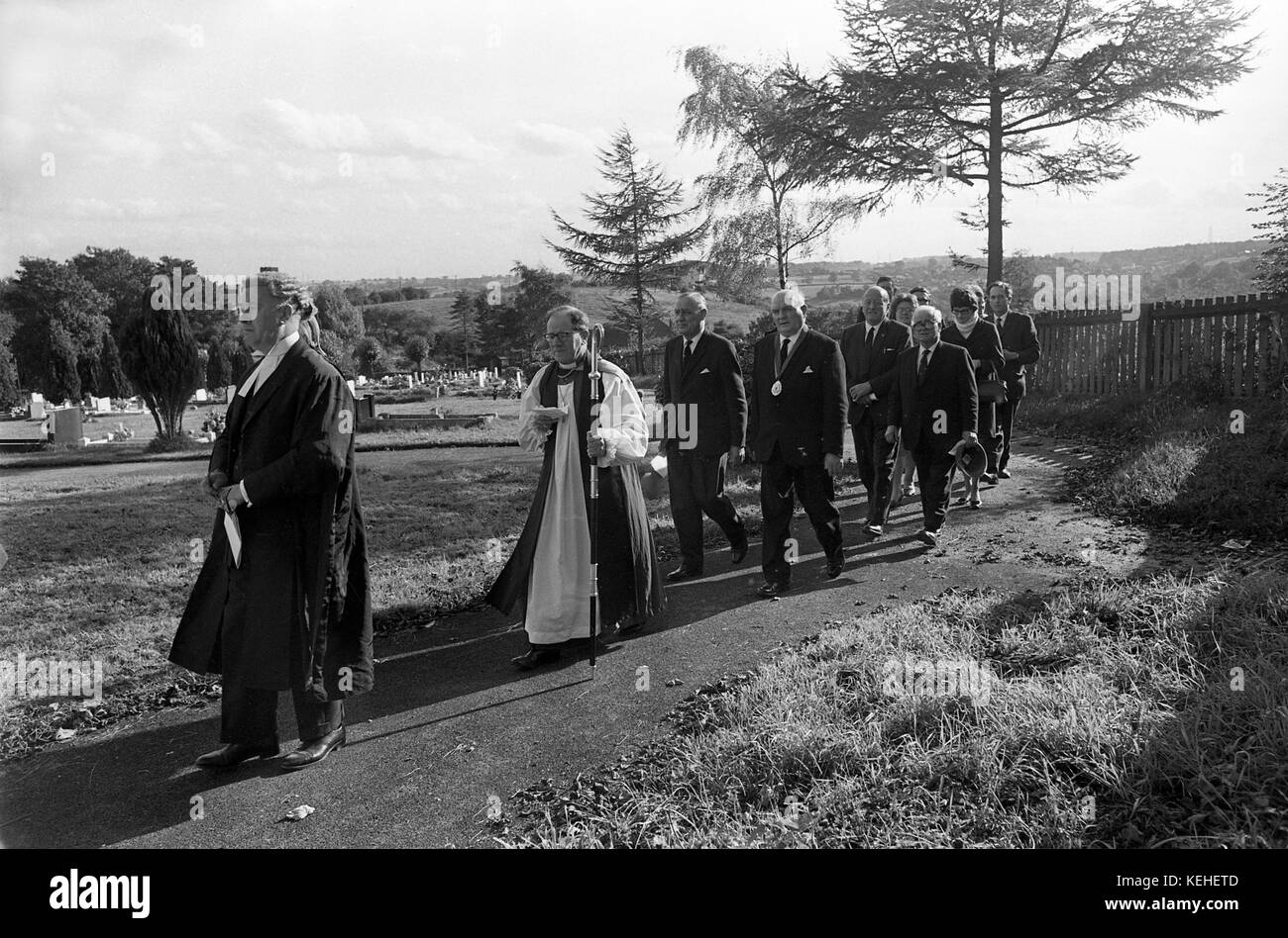 Die Mitglieder des Klerus und Officals weihen eine Grabstätte auf einem Sportplatz Friedhof weihe Service 1968 Stockfoto
