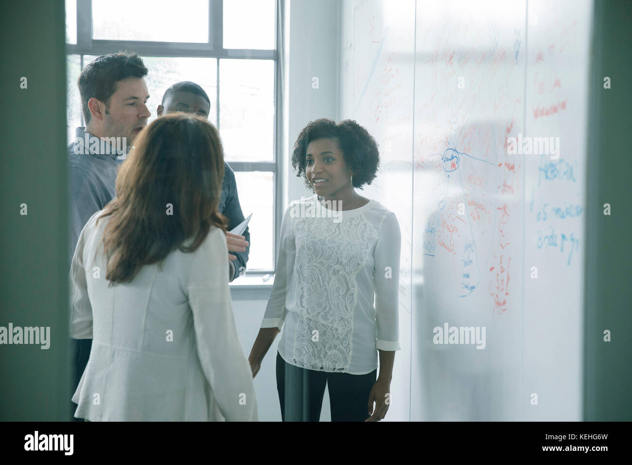 Geschäftsleute, die sich in Meetings in der Nähe des Whiteboards unterhalten Stockfoto