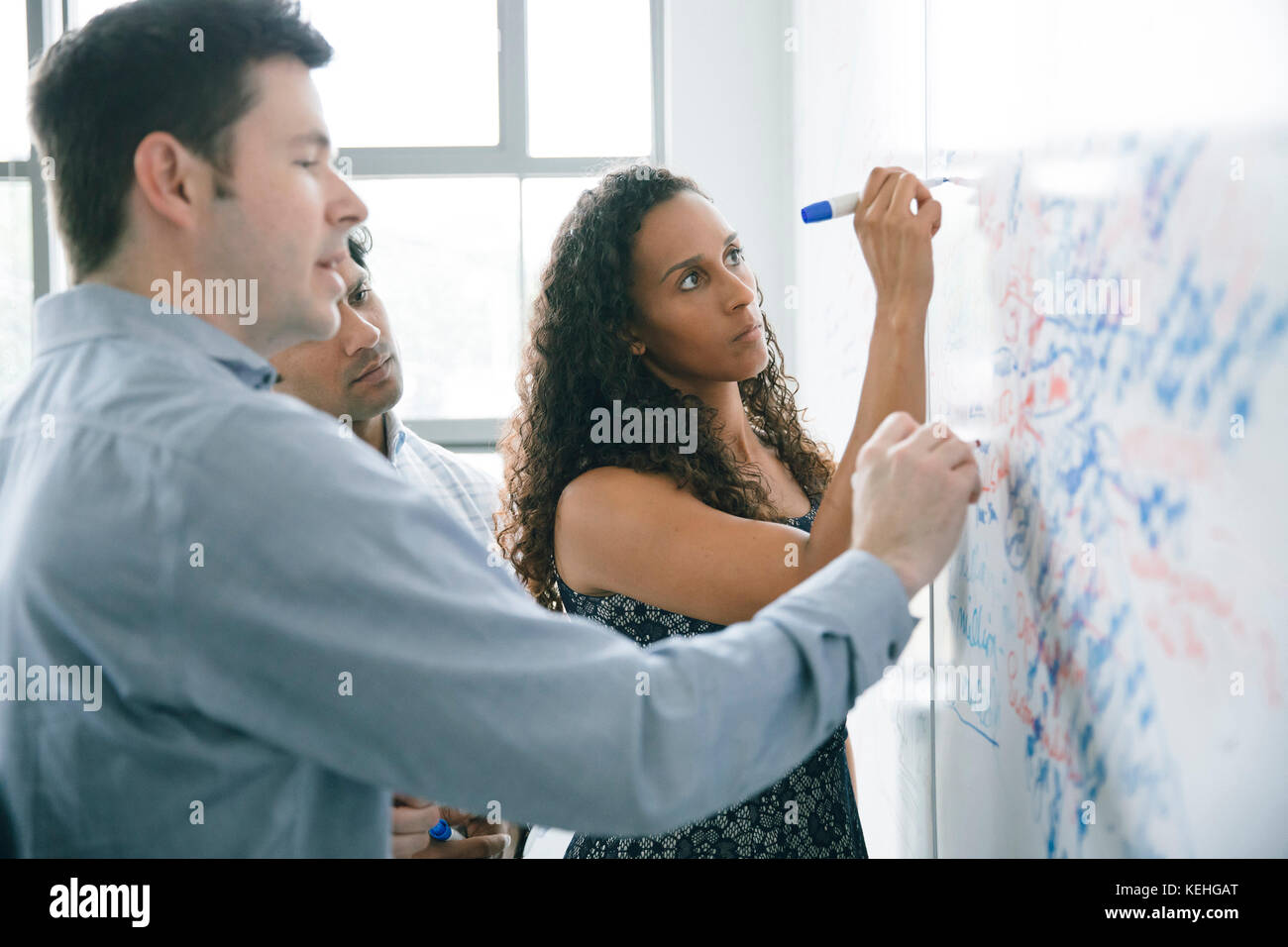 Geschäftsleute schreiben in Meetings auf Whiteboard Stockfoto
