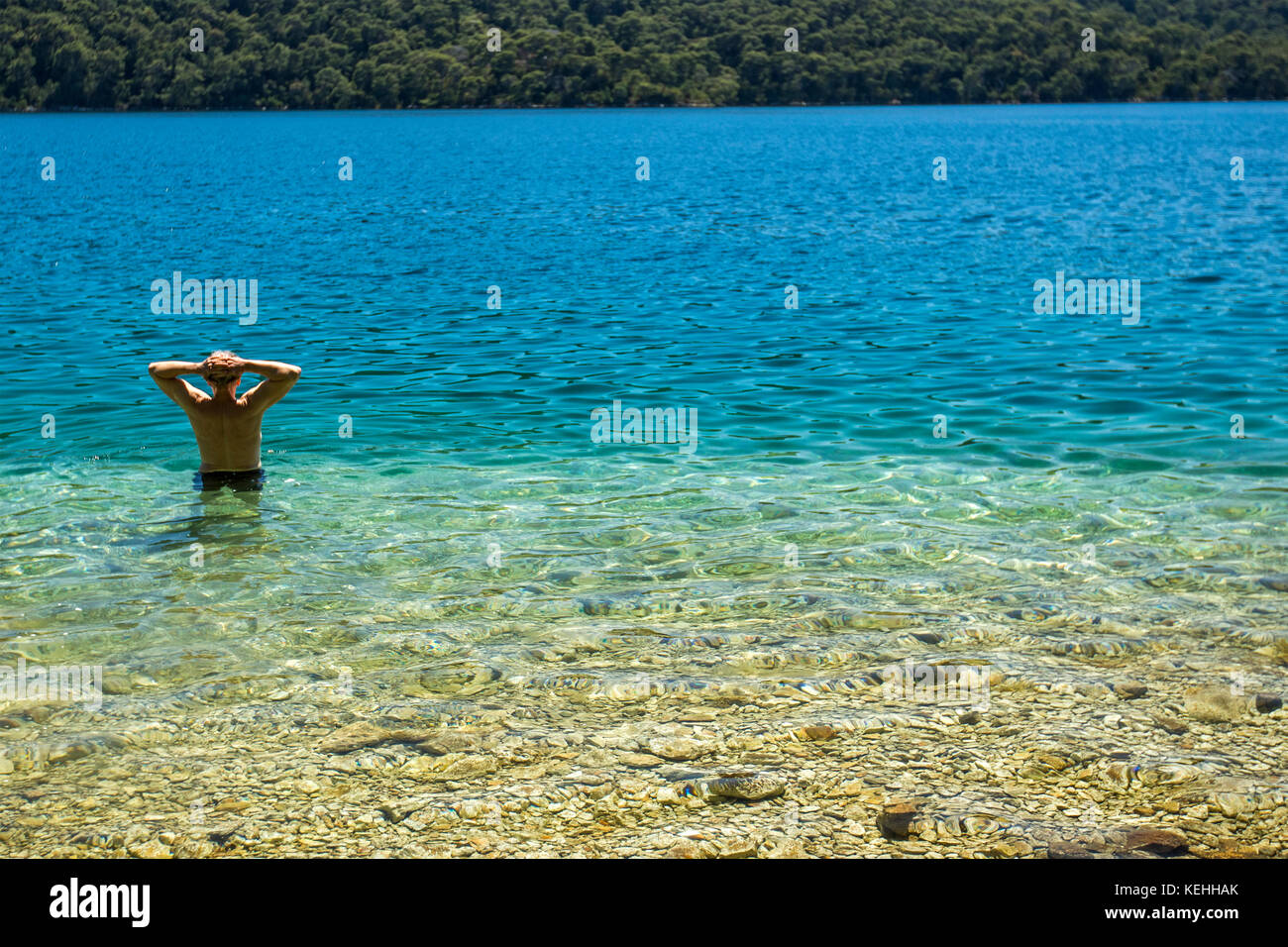 Kaukasischer Mann watend im Wasser Stockfoto
