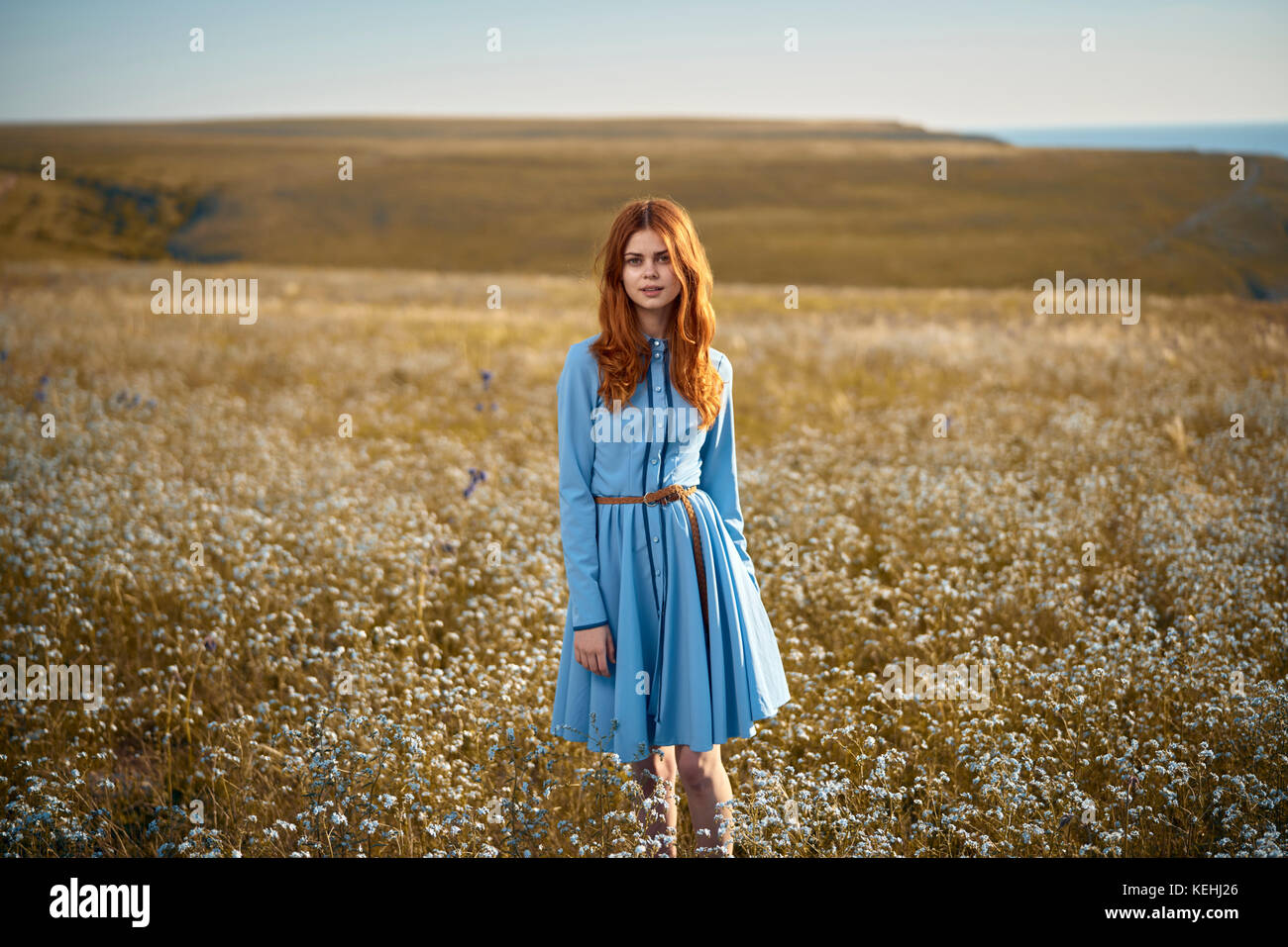 Kaukasische Frau, die in einem Feld von Wildblumen steht Stockfoto