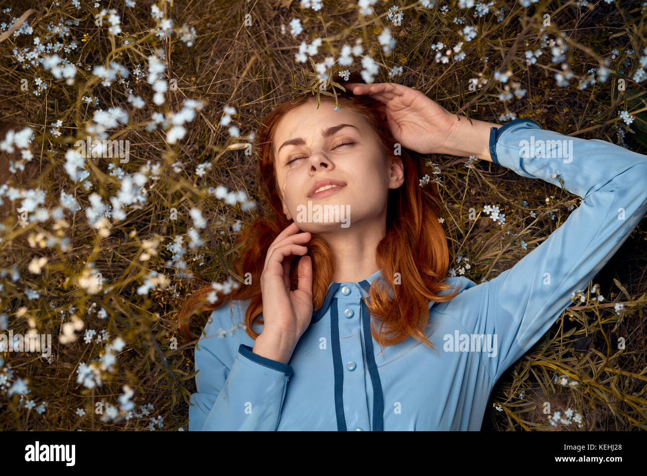 Kaukasische Frau, die im Feld der Wildblumen liegt Stockfoto