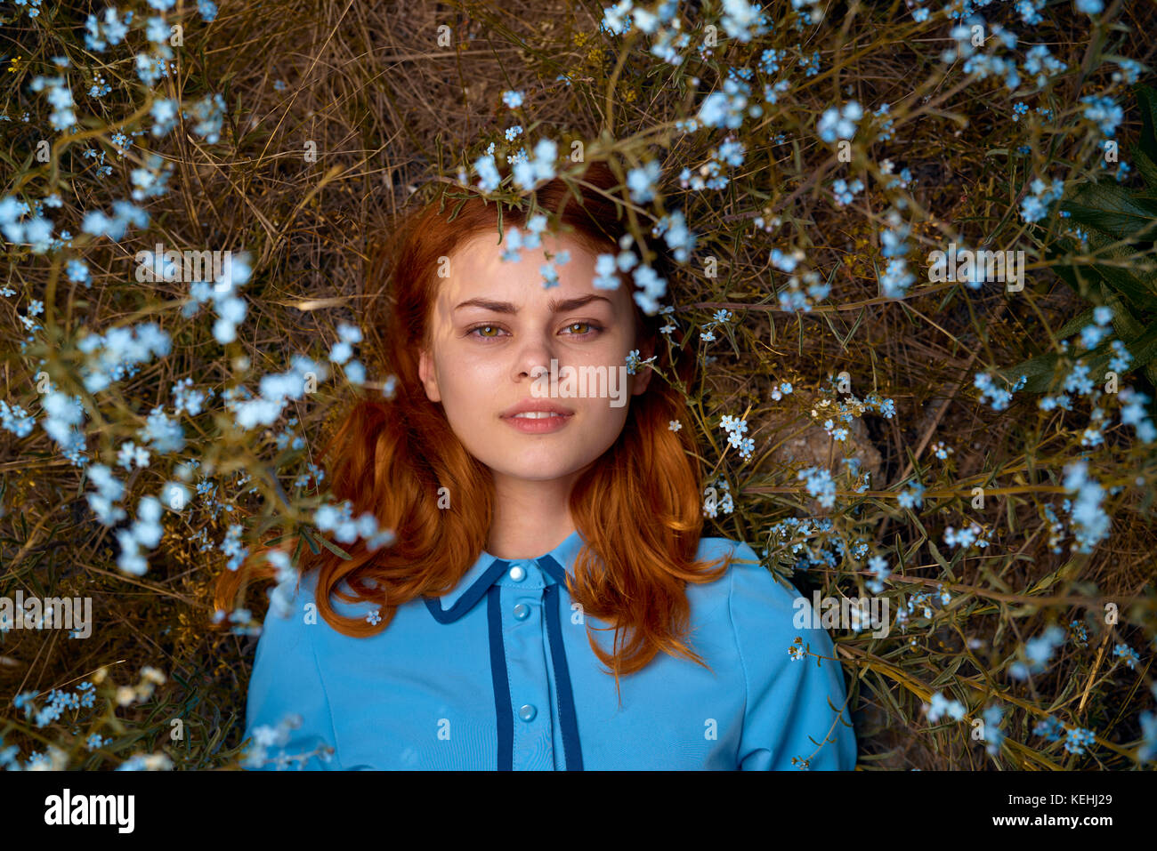 Kaukasische Frau, die im Feld der Wildblumen liegt Stockfoto
