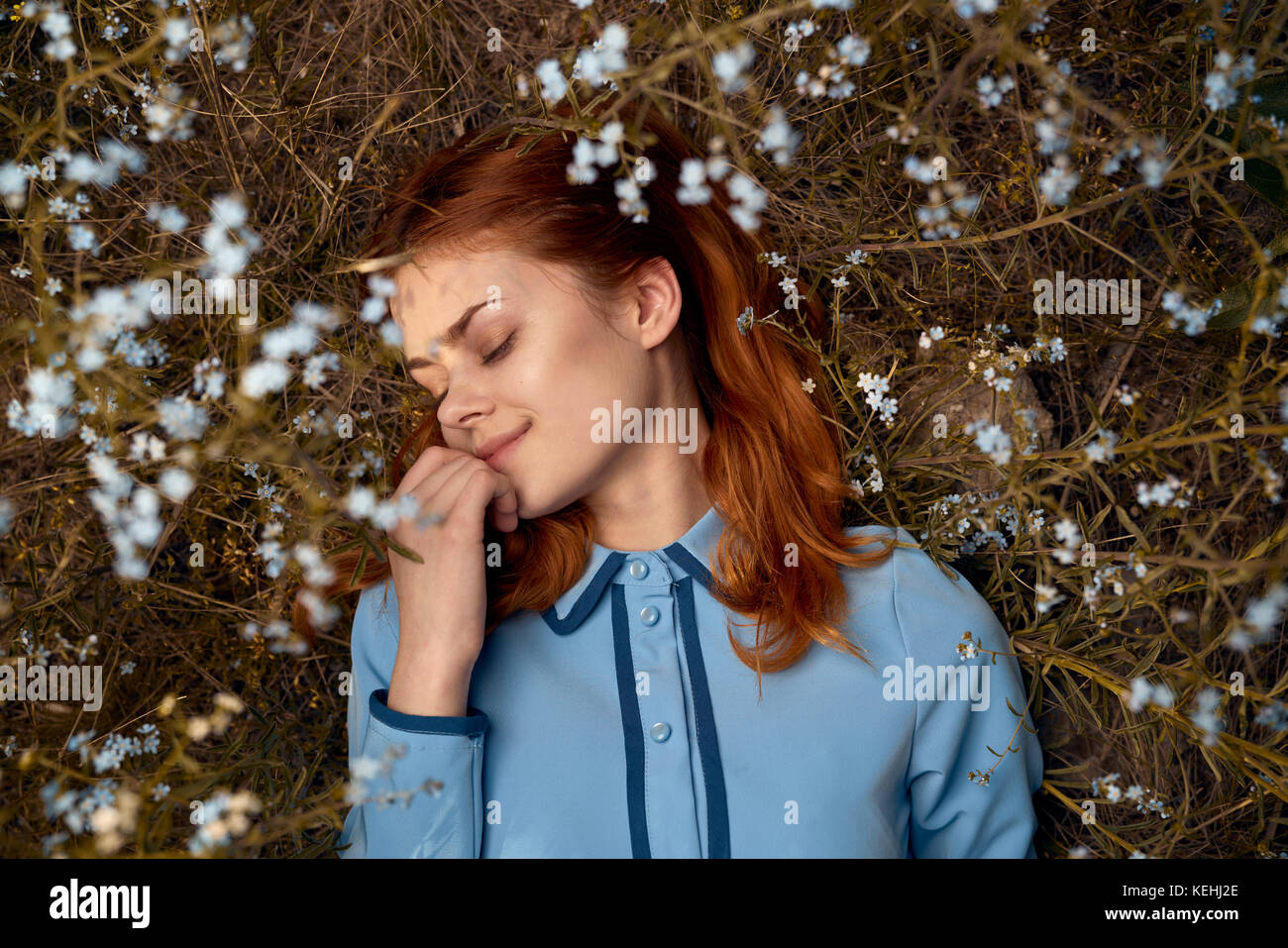 Kaukasische Frau, die im Feld der Wildblumen liegt Stockfoto