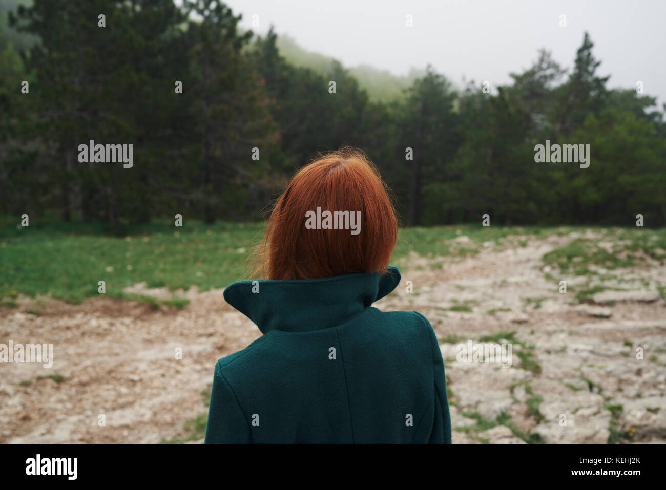 Kaukasische Frau trägt einen Mantel mit einem Kragen im Feld Stockfoto