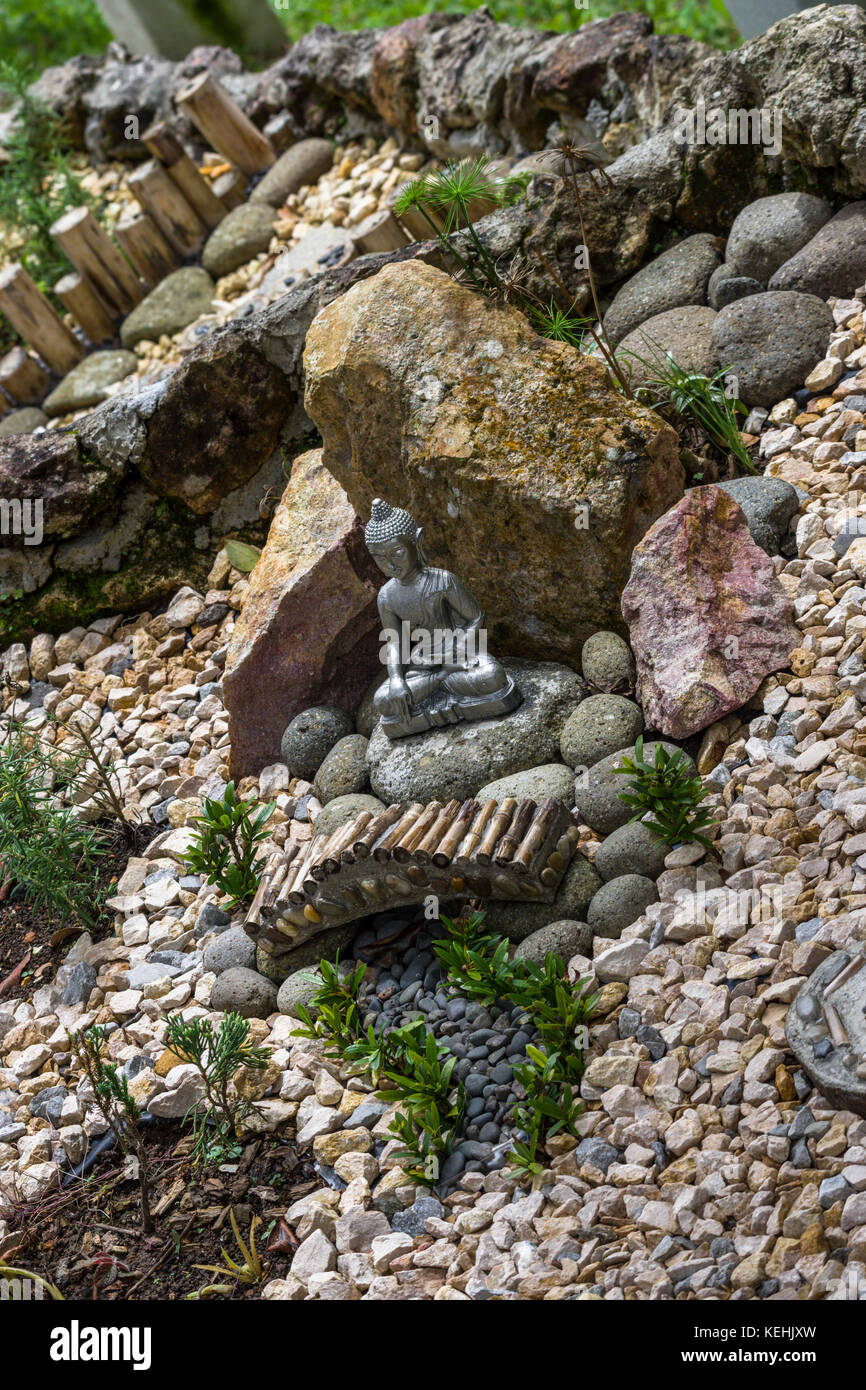 Garten Ideen Zen Stone Garten mit kleiner sitzender Buddha Statue Stockfoto