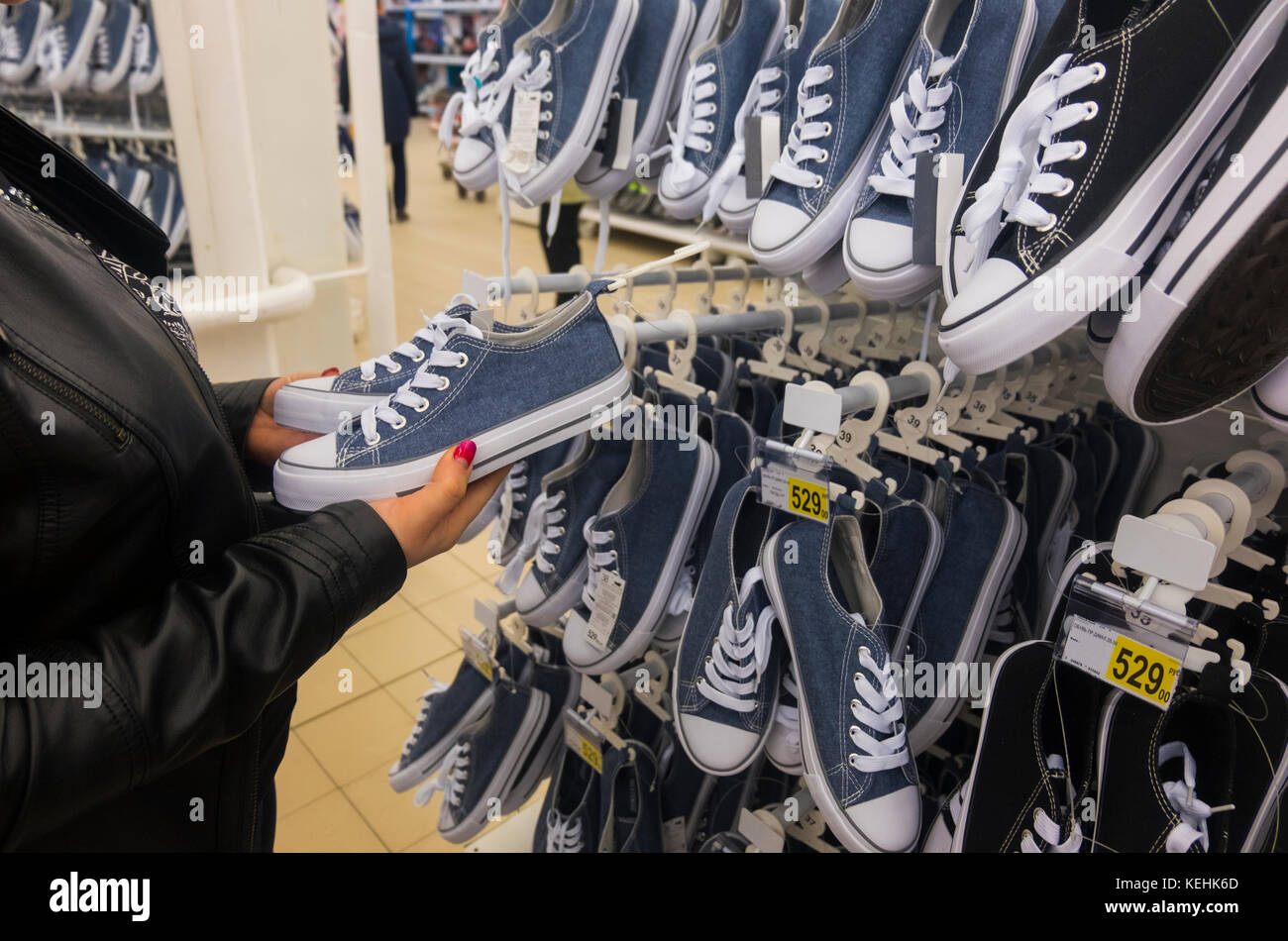 Die Hände der kaukasischen Frau mit Sneakers in Store Stockfoto