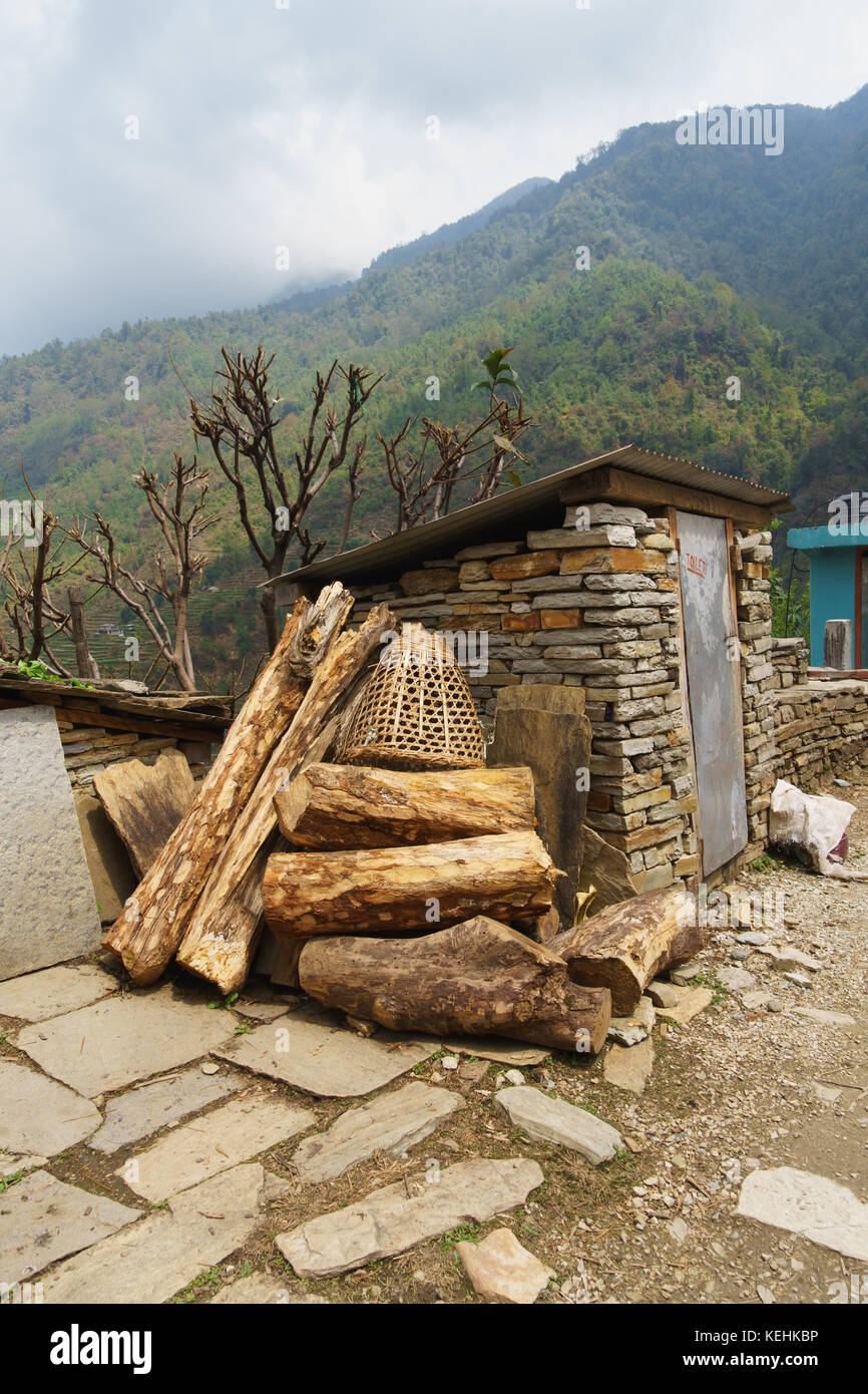 Protokolle und Weidenkorb im Freien gelagert, Annapurna region, Nepal. Stockfoto