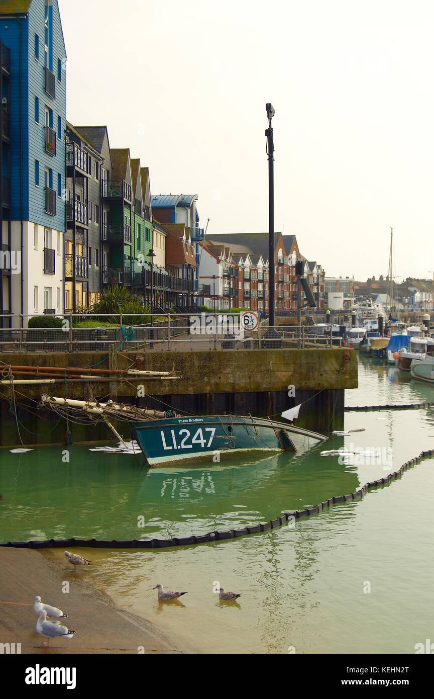 Ein kleines Boot ist im Fluss Arun, im Hafen von Littlehampton, Littlehampton, Großbritannien, zerstört Stockfoto