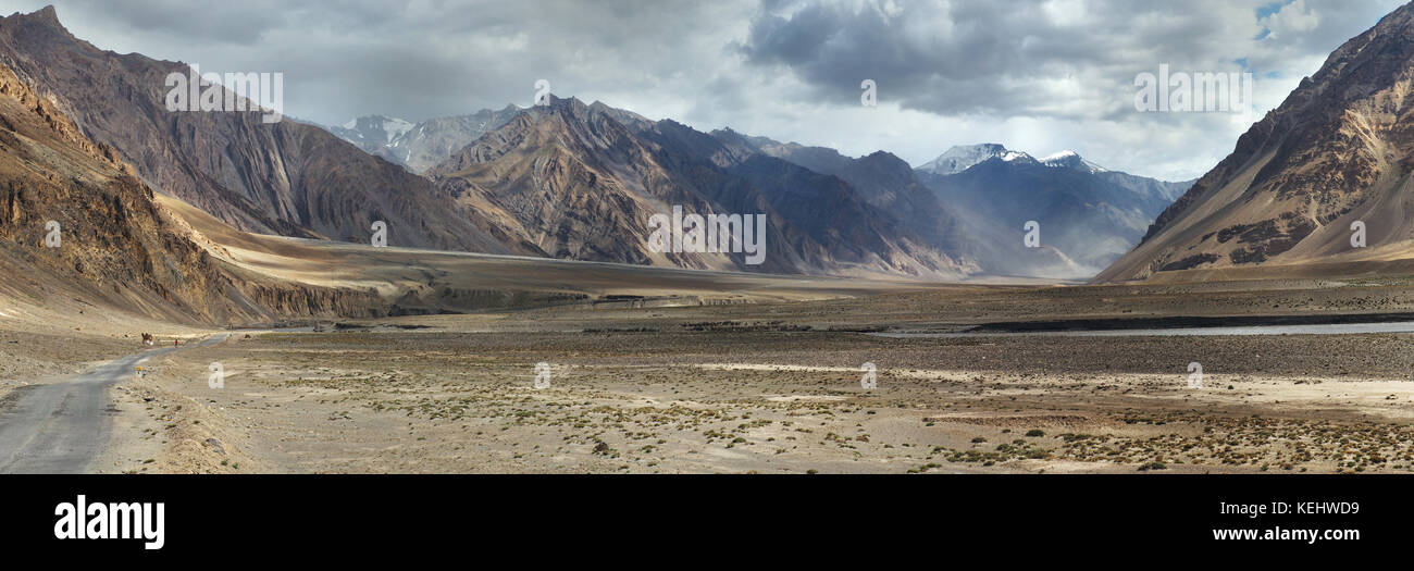 Panorama Foto hohe Berge Tal: Breite braune Hügel Canyon, unter grauen Abend Himmel mit Wolken, Nebel liegt auf den Pisten, Tibet. Stockfoto