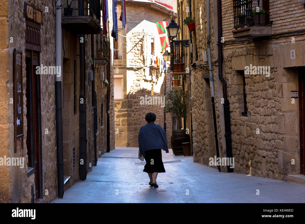 Frau walkingin Calle de Cuatro Cantones in der Stadt von Laguardia in Rioja-Alavesa Bereich von Spanien Stockfoto