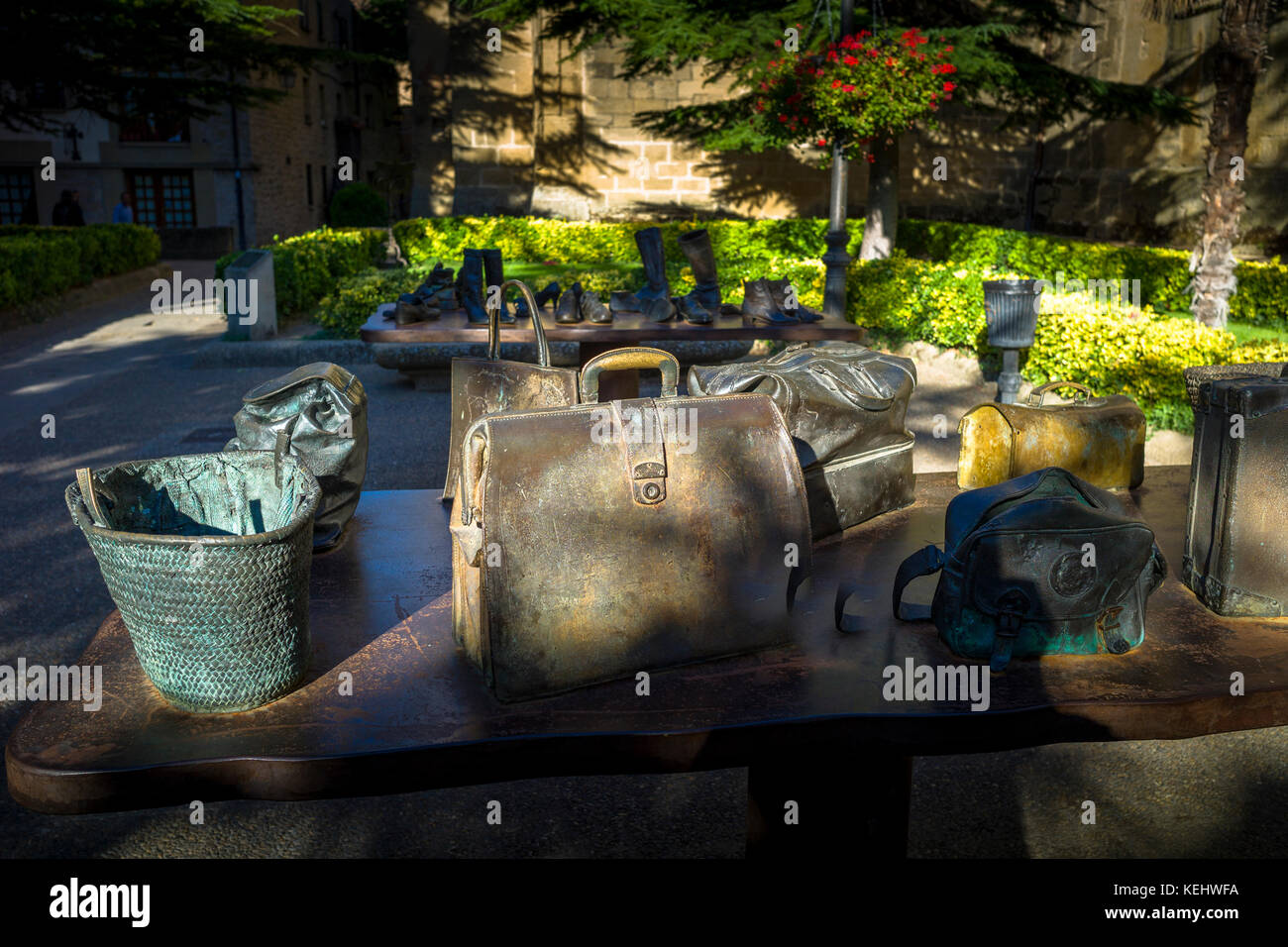 Zeitgenössische Bronzeskulpturen von Koko Rico von Handtaschen und Reisetaschen auf dem Tisch in Plaza el Gaitero, LaGuardia, Rioja, Spanien Stockfoto