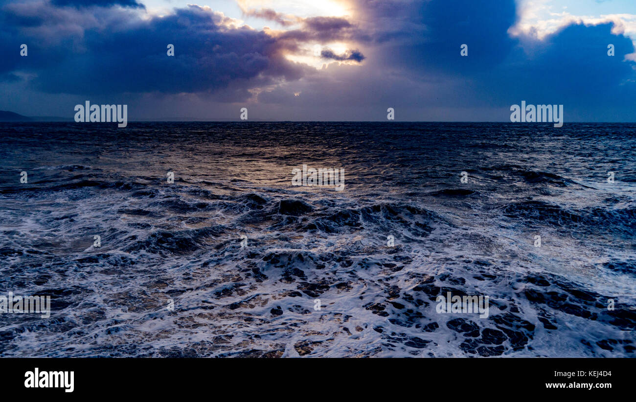 Sonnenlicht bricht durch die schweren Wolken. Dramatische Küstenansicht am frühen Morgen als der Atlantische Sturm Brian im Süden Cornwall, Großbritannien erreicht Stockfoto