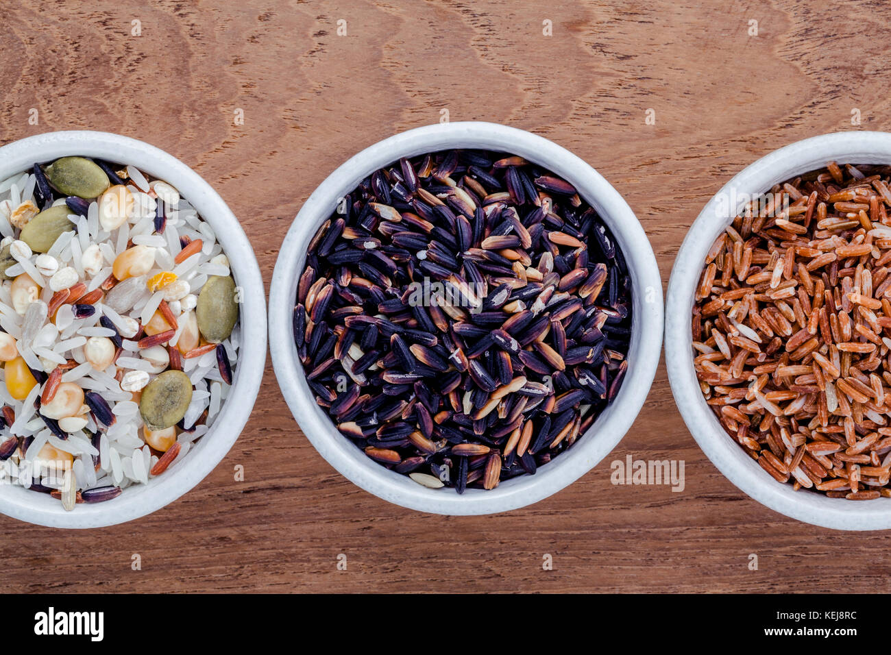 Auswahl an traditionellen Thai Reis in Keramik Schüssel auf Holz- Hintergrund. Das Abendessen essen hohen Faser- und Vitamin E für Ernährung und gesundes Essen. Stockfoto