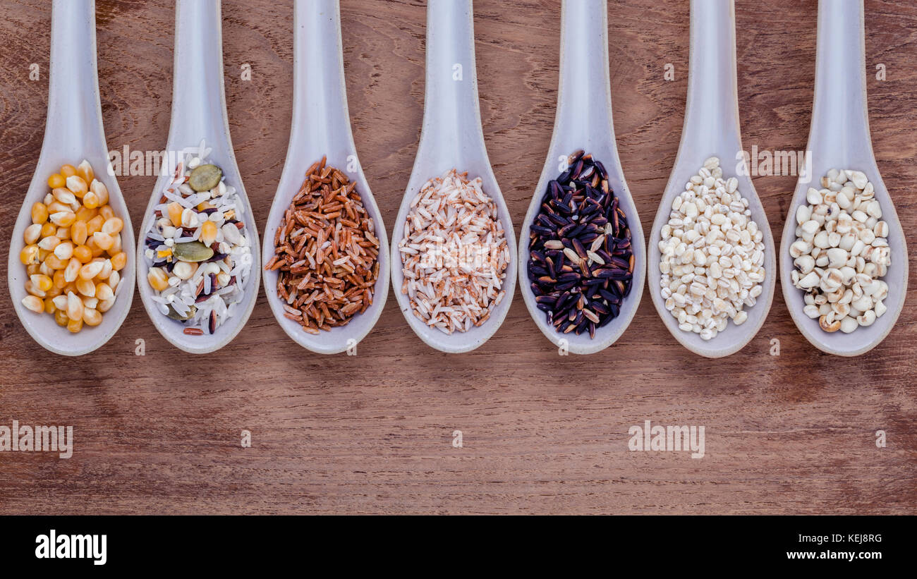 Auswahl an traditionellen Thai Reis im Löffel auf Holz- Hintergrund. Das Abendessen essen hohen Faser- und Vitamin E für Ernährung und gesundes Essen. Stockfoto