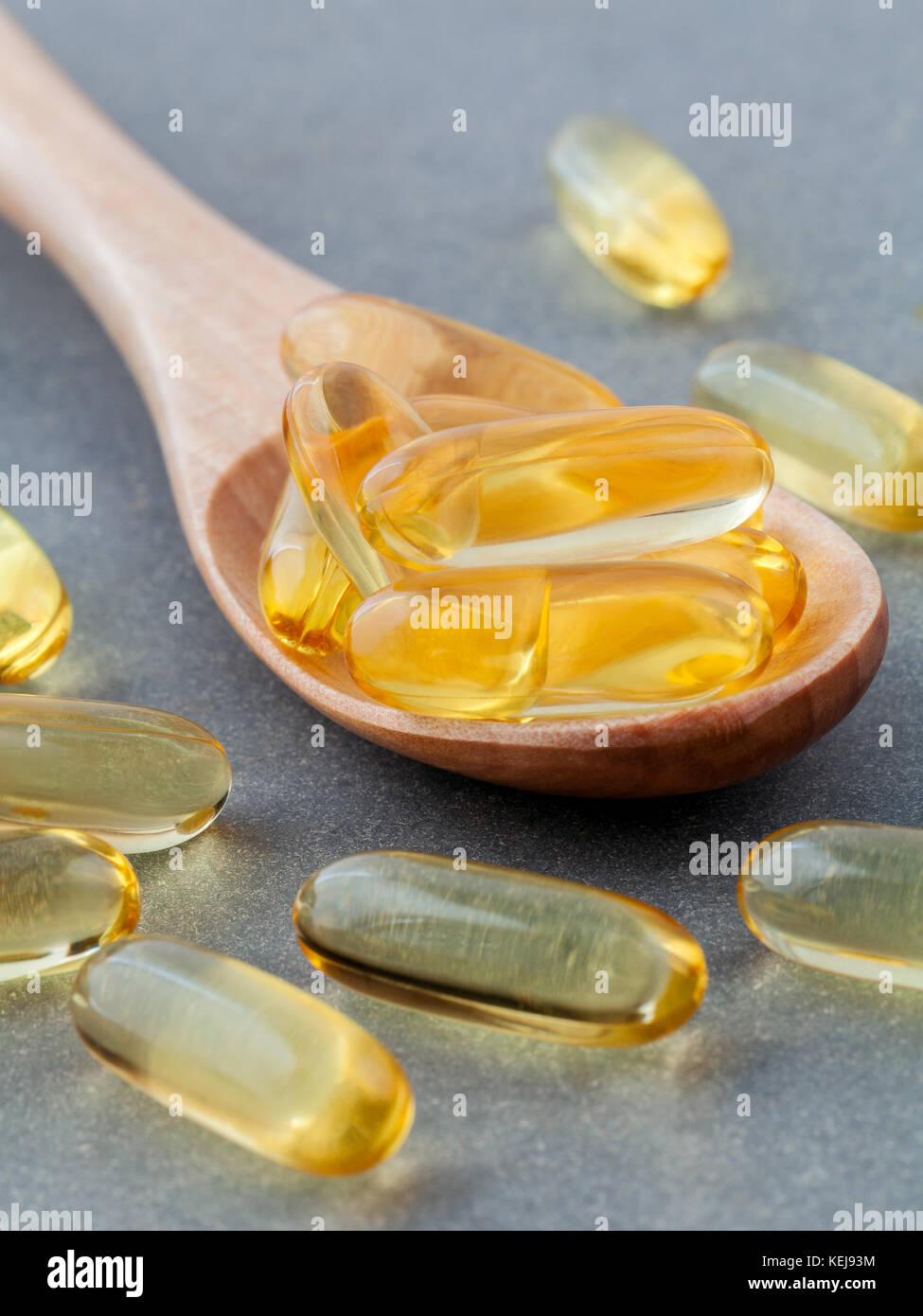 Nahaufnahme kapseln Fischöl in der Löffel aus Holz. die Ergänzung hoher Vitamin E, Omega 3, DHA und EPA Stockfoto