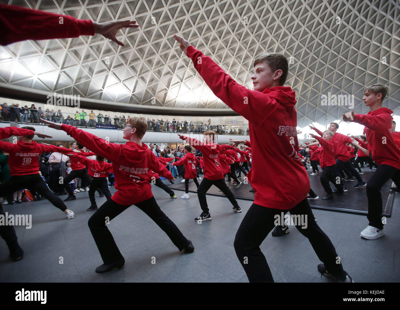 Amateur- und professionelle männliche Darsteller im Alter von 6-12 Jahren, die an einem Flash Mob teilnehmen, der im Rahmen der Royal Academy of Dance Project B Kampagne organisiert wird, um mehr Jungen zu ermutigen, Ballett in King's Cross Station, London, auszuprobieren. Stockfoto