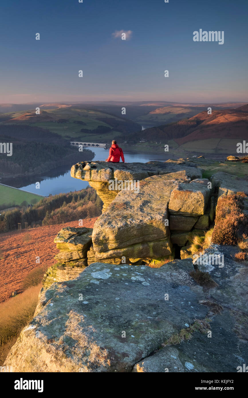 Walker sitzen auf Bamford Kante über dem Ladybower Reservoir, Nationalpark Peak District, Derbyshire, England, UK MODEL RELEASED Stockfoto