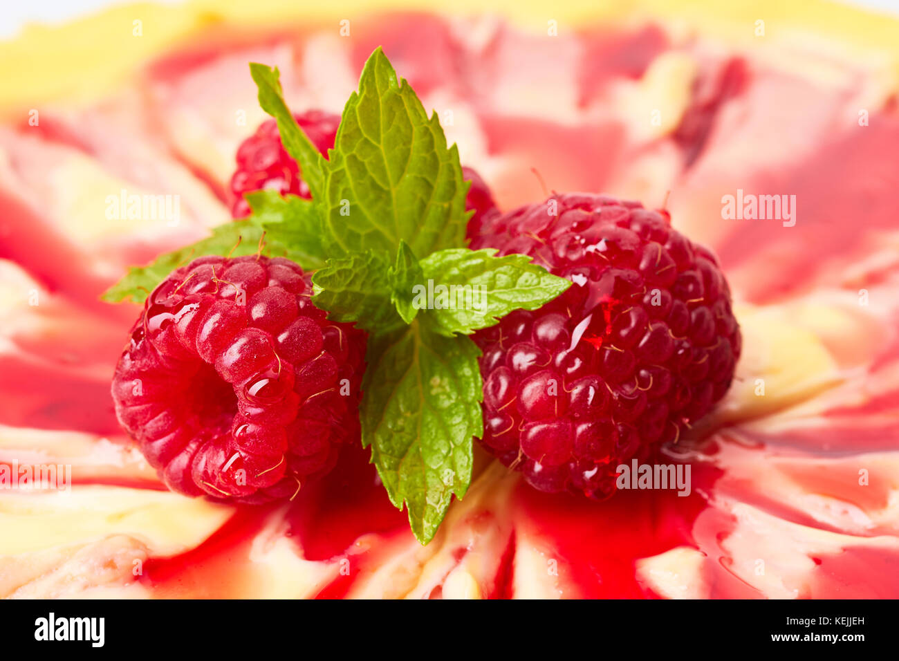 Drei Himbeeren und Minze auf Käsekuchen Stockfoto