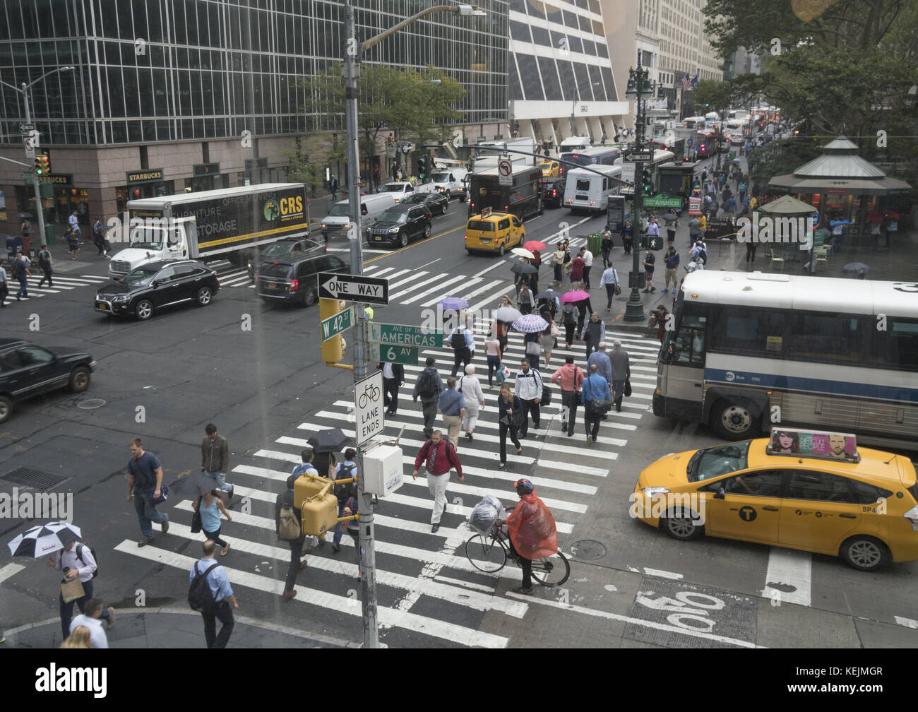 Menschen und Verkehr überqueren die 6th Avenue entlang der 42nd Street am Bryant Park in Midtown Manhattan. Stockfoto