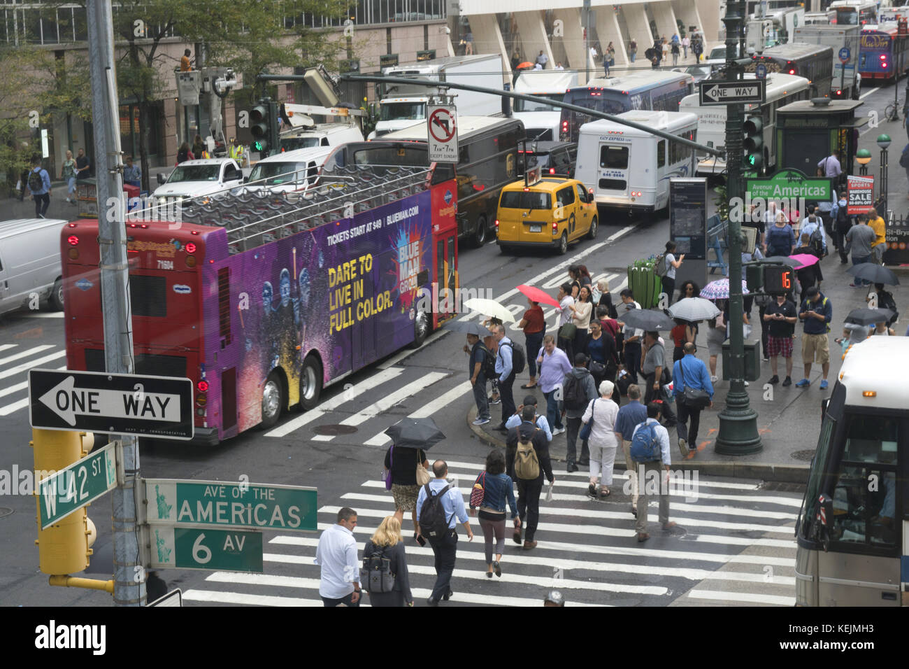 Menschen und Verkehr überqueren die 6th Avenue entlang der 42nd Street am Bryant Park in Midtown Manhattan. Stockfoto