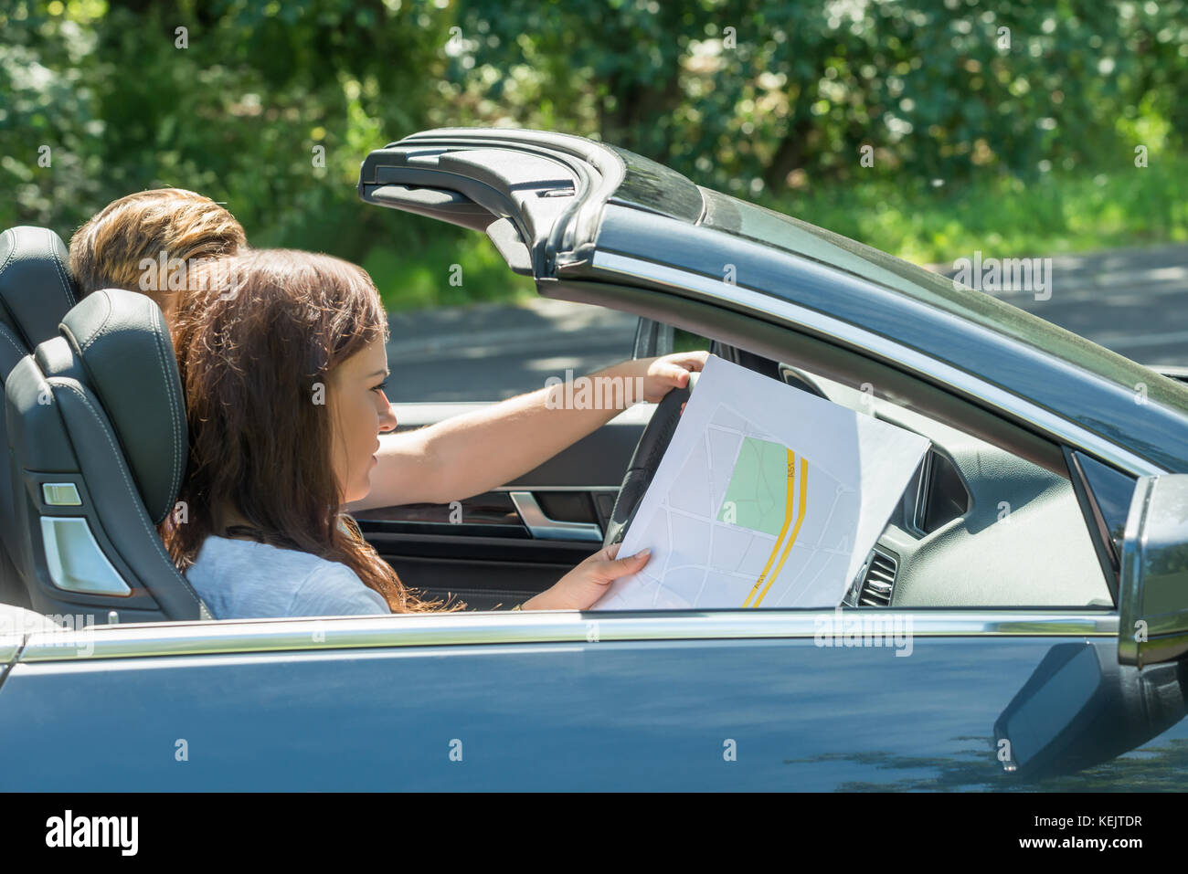 Seitenansicht einer jungen Frau auf der Suche auf Karte während der Mann Auto Stockfoto