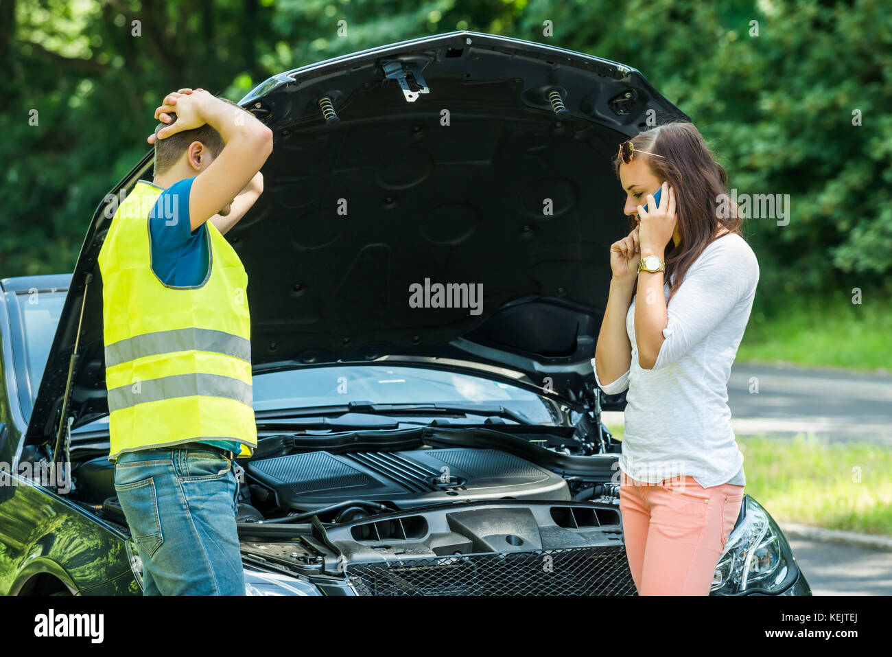 Mann an Frau Gespräch am Handy mit nach Auto suchen auf der Straße Stockfoto
