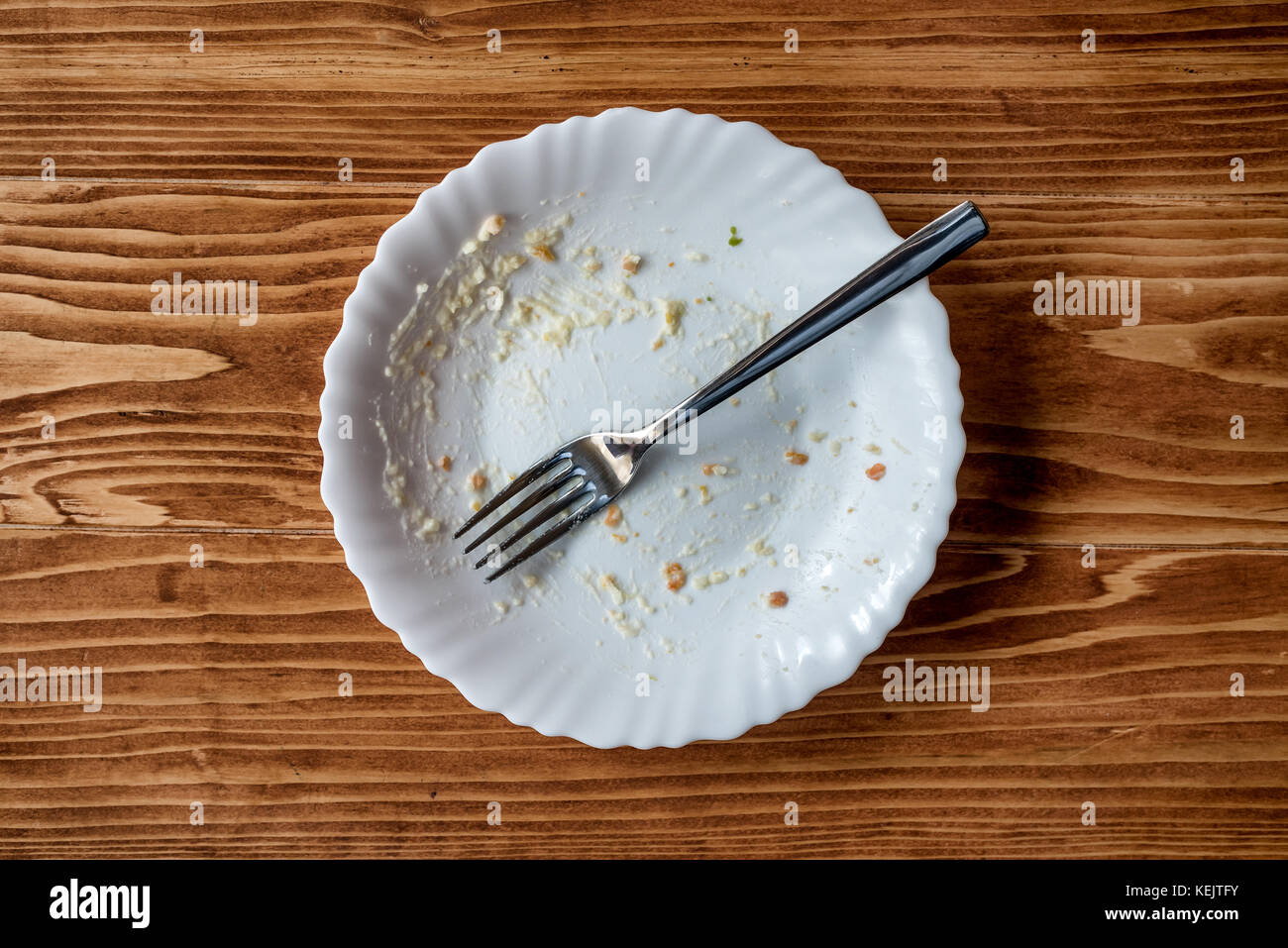 Leeren Teller mit Essen Reste nach dem Essen auf einen hölzernen Tisch Stockfotografie