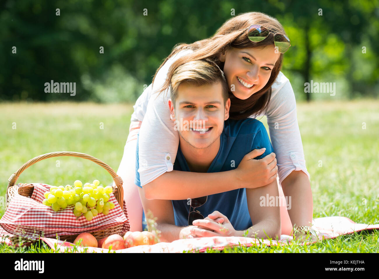 Portrait von glückliches junges Paar Verlegung auf Decke in Park Stockfoto