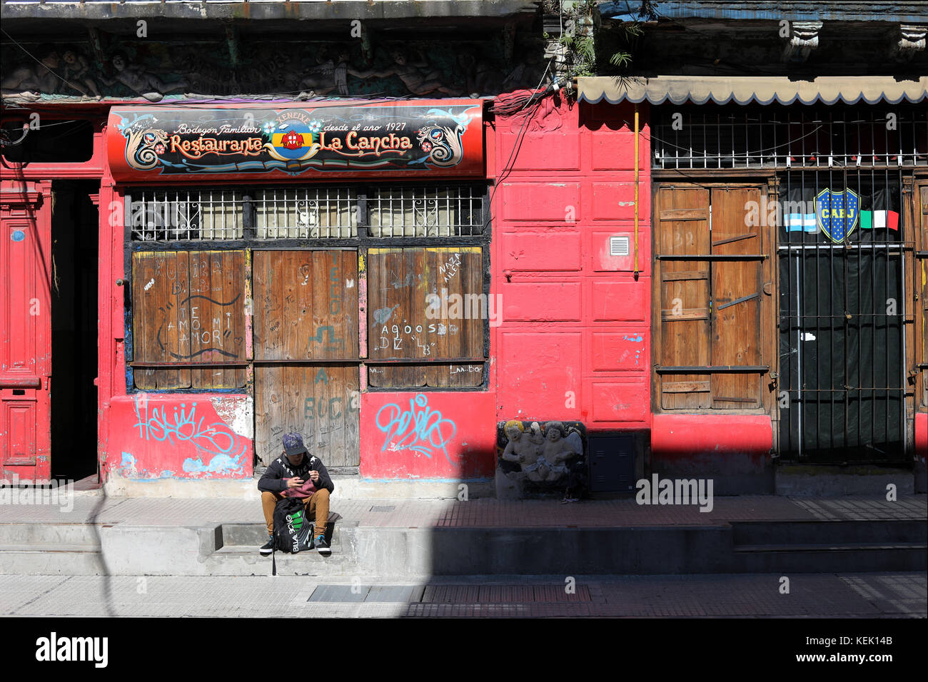 CAMINITO, LA BOCA, BUENOS AIRES, ARGENTINIEN - Oktober 2017 - Typische Straße von caminito in der Nachbarschaft von La Boca. Eine nicht identifizierte Person sitti Stockfoto