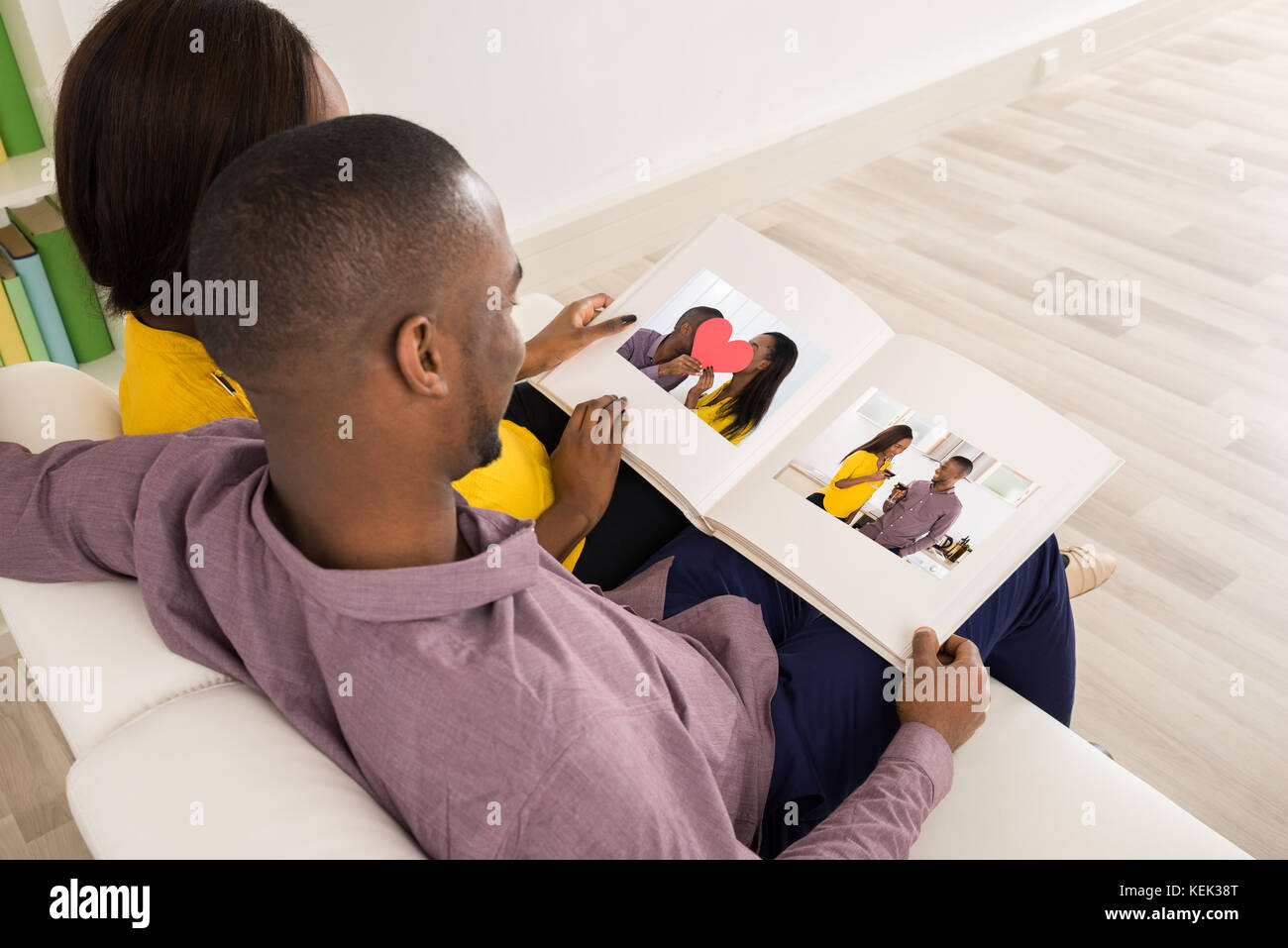 Paar sitzt auf einem Sofa mit Blick auf Fotoalbum Stockfoto