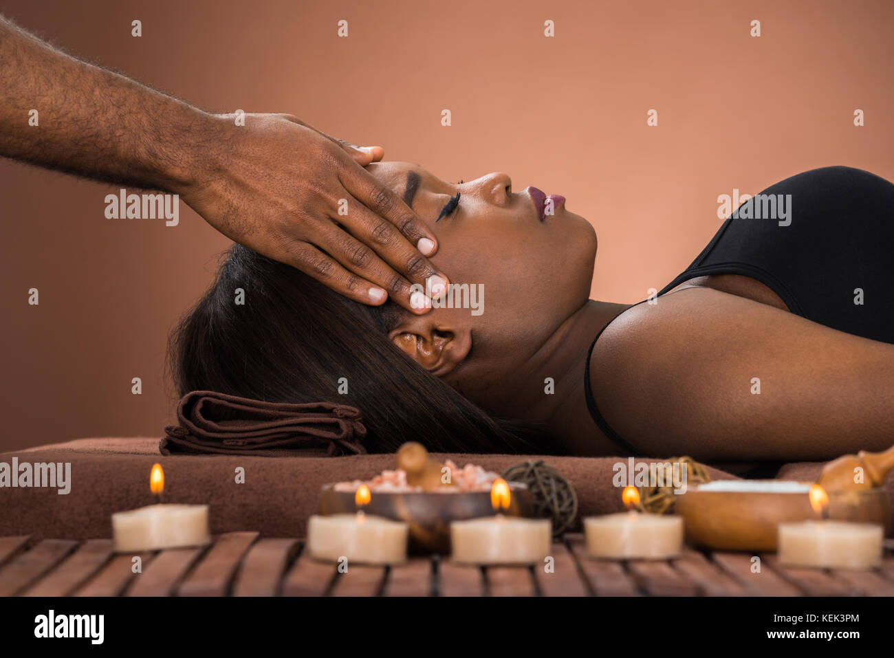 Entspannt Junge afrikanische Frauen, die Stirn Massage im Spa Stockfoto