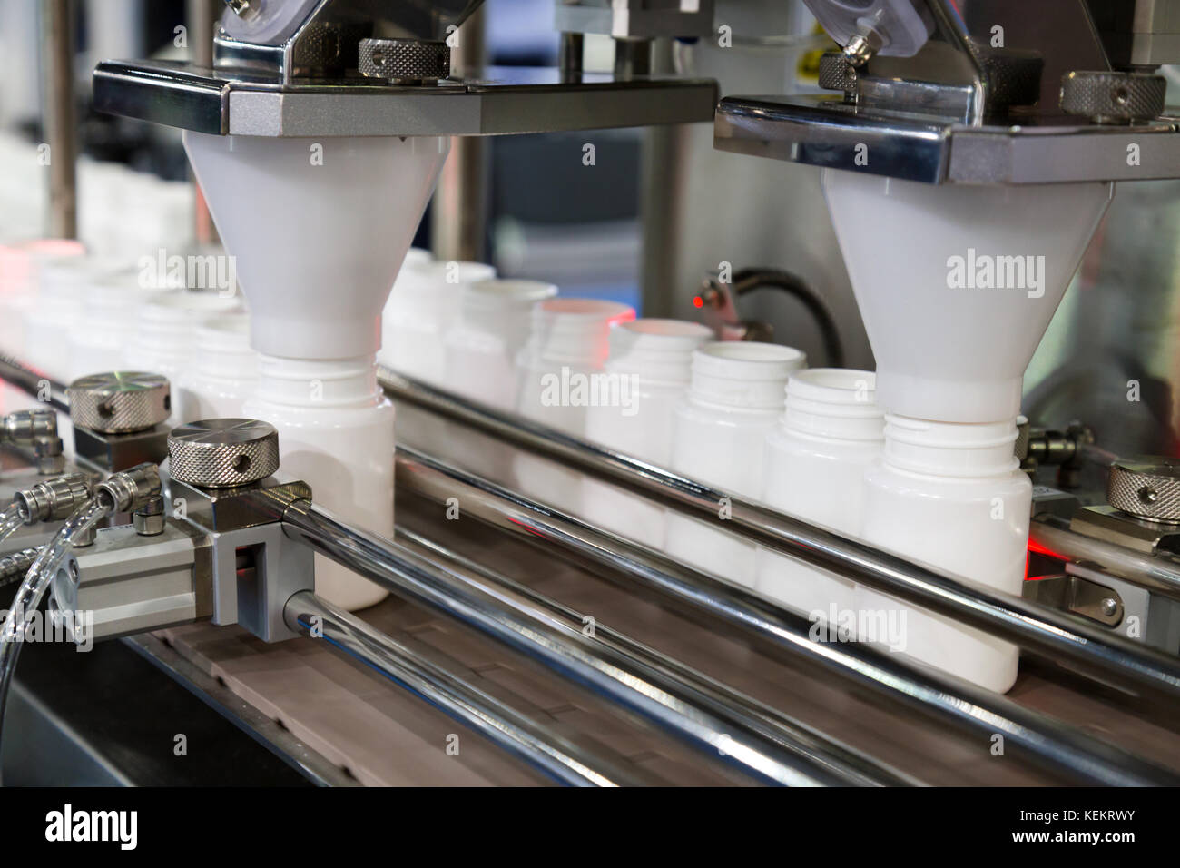 Weißer Kunststoff Flaschen auf der Produktionslinie des Förderbandes an der Füllmaschine in der Fabrik. Selektive konzentrieren. Stockfoto