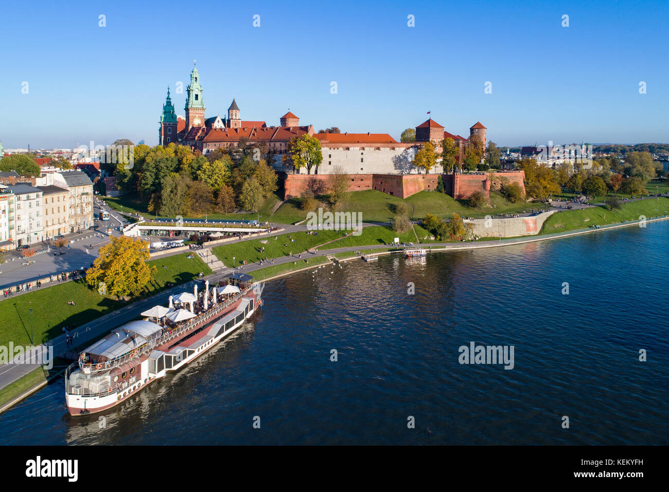 Krakau, Polen. Mit königlichen Schloss Wawel, Kathedrale, Weichsel, Hafen, Schiff und an Bord Restaurant. Luftaufnahme im Herbst im Abendlicht. Stockfoto