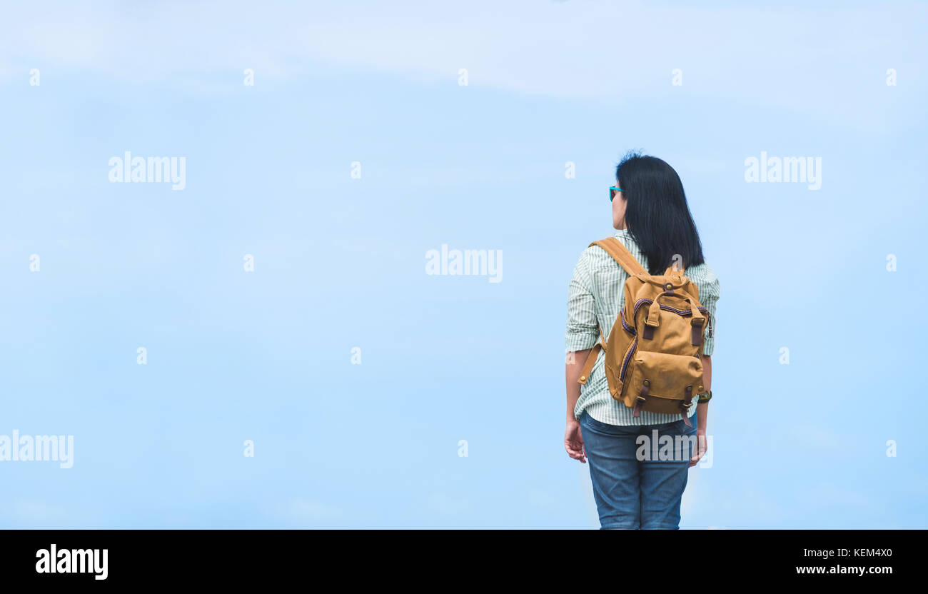 Reisende mit Rucksack auf blauen Himmel, Asien Frau Backpacker stehen auf der Straße und freuen uns zu sehen, freedon Reise Konzept Stockfoto
