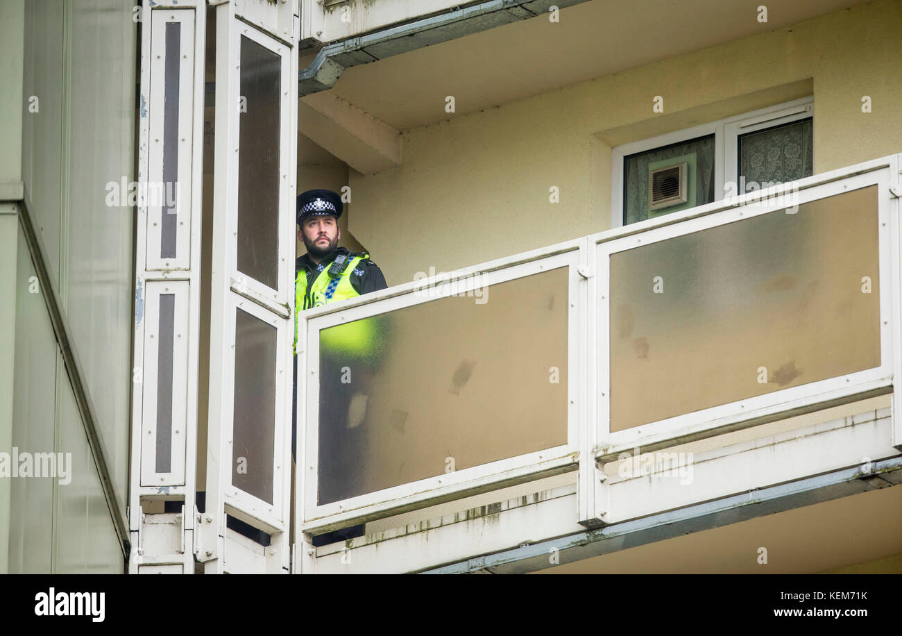 Ein Polizist auf einem Balkon in Newcastle Haus in Bradford, wo ein 18 Monate altes Baby starb nach einem Sturz aus dem sechsten Stock Fenster, eine 23-jährige Frau wurde wegen des Verdachts auf Mord in Zusammenhang mit dem Baby fallen verhaftet. Stockfoto