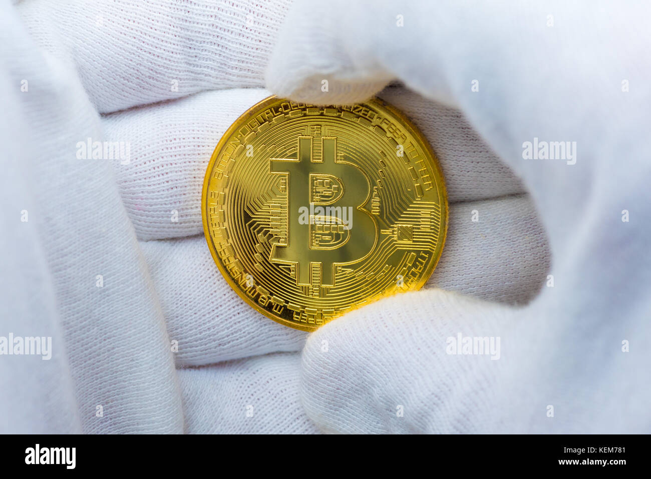 Hände mit weißen Handschuhen mit einem goldenen Bitcoin Stockfoto