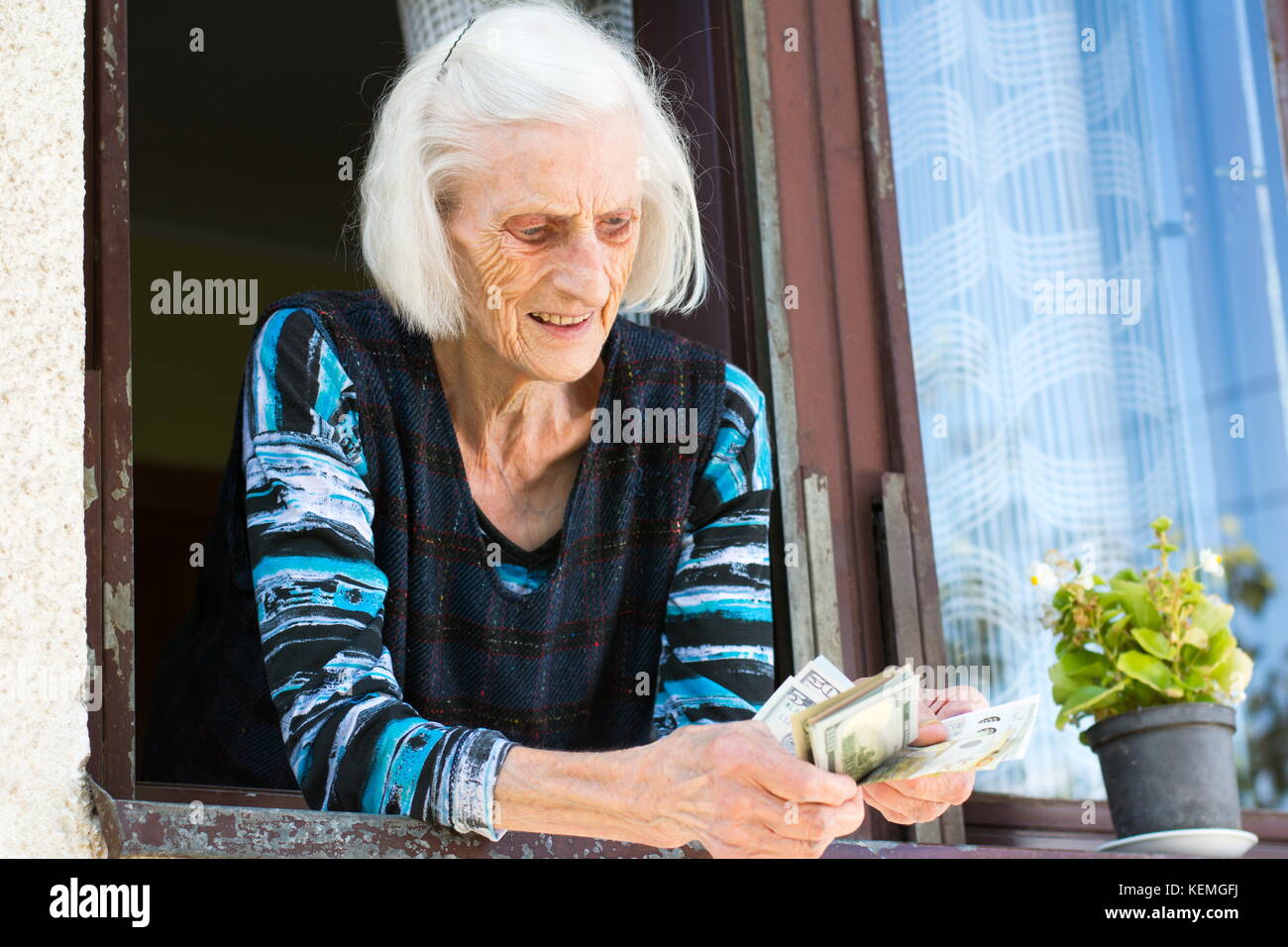 Oma zählen Ruhestand Geld zu Hause am Fenster zu Hause Stockfoto