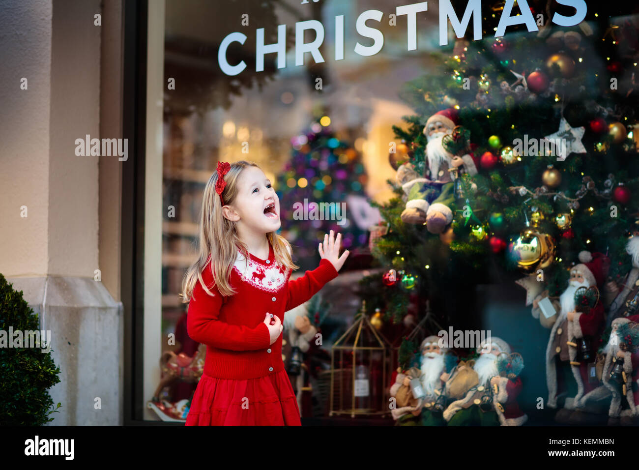 Kinder Einkaufen für Weihnachtsgeschenke. Kinder kaufen Weihnachten  Dekoration und Baum. kleines Mädchen an dekorierten Schaufenster mit  Lichtern und Santa Spielzeug. Familie b Stockfotografie - Alamy