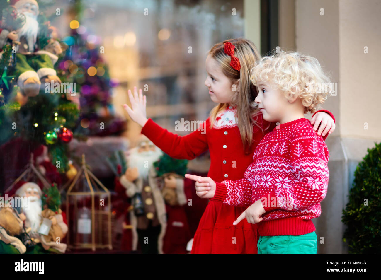 Kinder Einkaufen für Weihnachtsgeschenke. Kinder kaufen Weihnachten  Dekoration und Baum. Kleines Mädchen und Jungen an der dekorierten  Schaufenster mit Lichtern und Santa Spielzeug Stockfotografie - Alamy