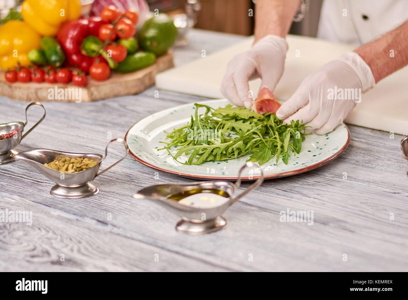 Küchenchef Feinkost Salat im Restaurant. Männliche chef Hände, Schinken auf Rucola kochen. Im Restaurant, Salat aus Rucola und Wichste Stockfoto