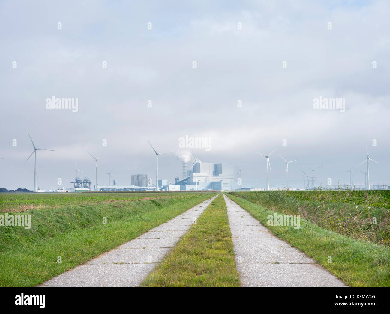 Kraftwerke und Windkraftanlagen hinter Feld bei Eemshaven im Norden von Groningen in den Niederlanden Stockfoto