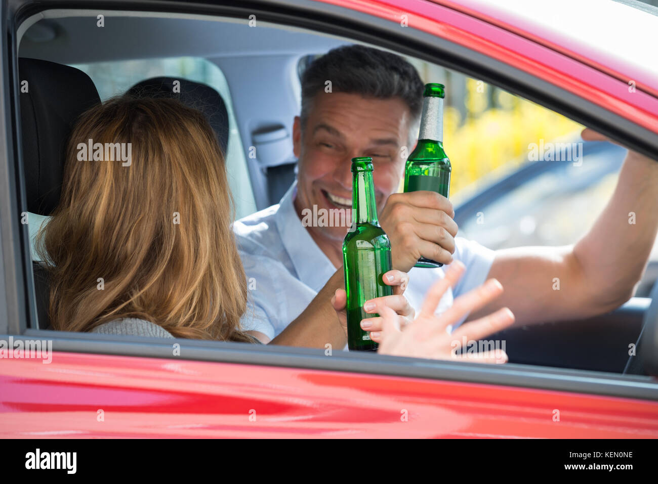 Close-up happy Reifes Paar im Auto sitzend Bier genießen. Stockfoto