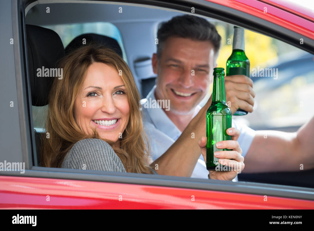 Close-up happy Reifes Paar im Auto sitzend Bier genießen. Stockfoto