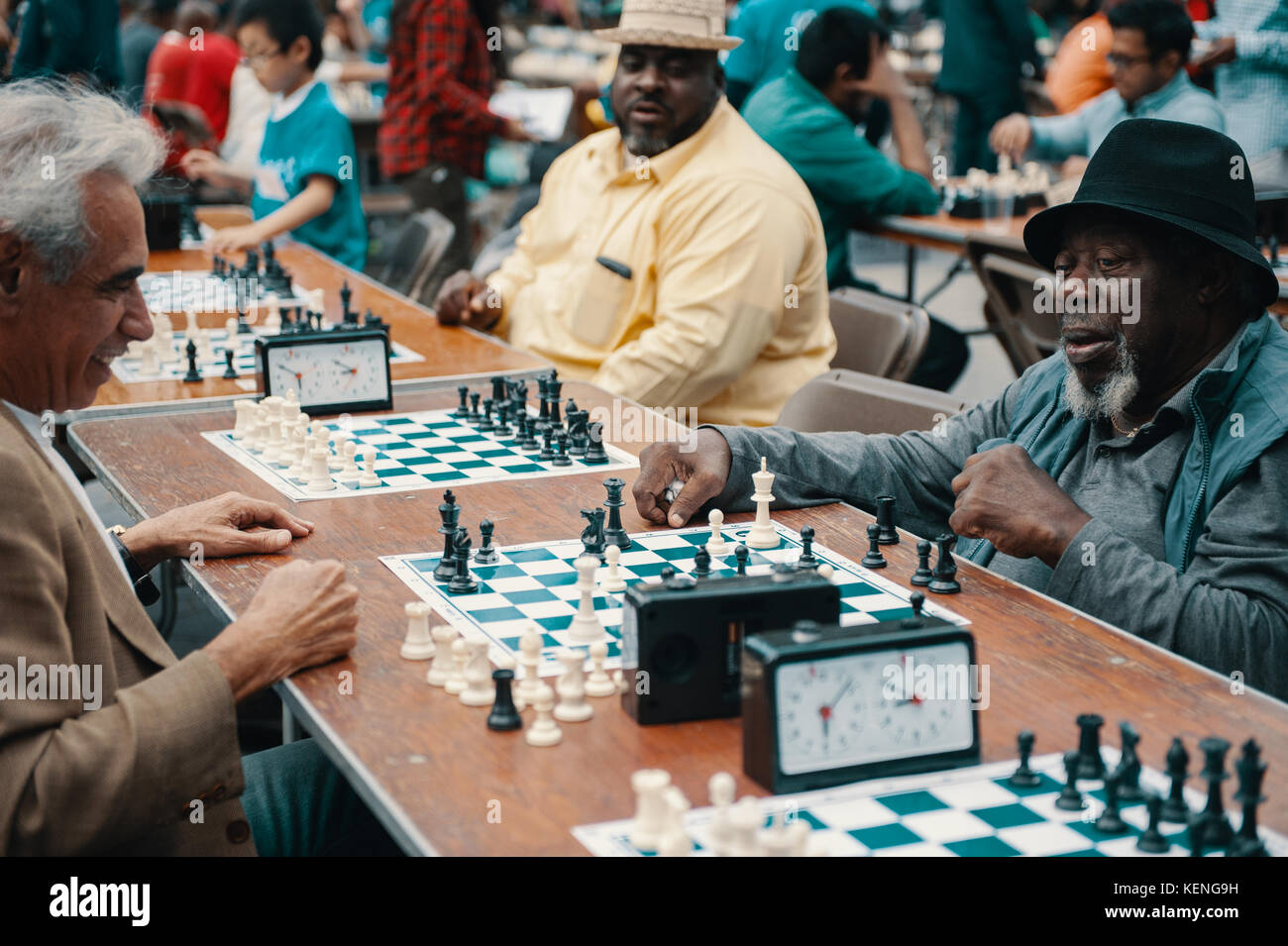 Alte afrikanische amerikanische älterer Mann Freizeitgestaltung durch Schach spielen im Central Park mit einer ethnischen Gruppe von Freunden. Stockfoto
