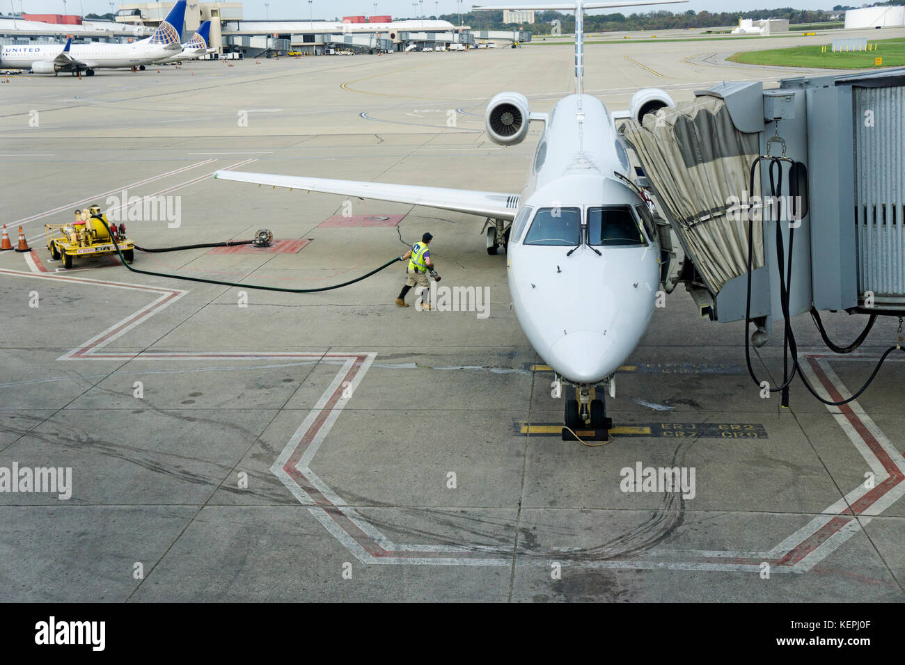 Ein Arbeiter auf der Rollbahn am Pittsburgh International Airport im Mond, Pa, über ein kleines Flugzeug zu tanken. Stockfoto