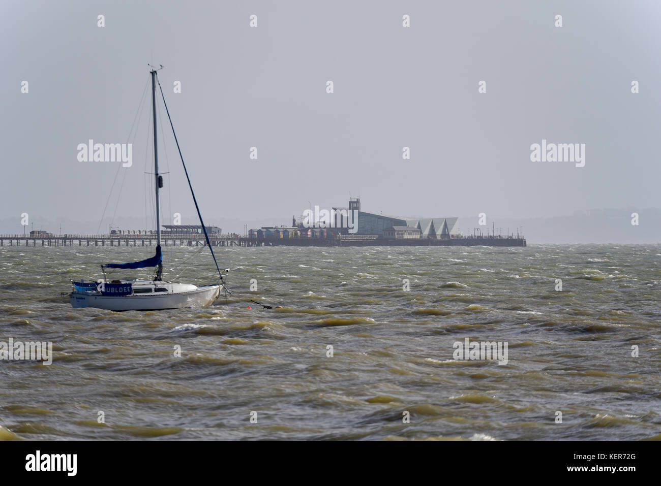 Yacht im rauen Meer vor Southend on Sea, Essex während Sturm Brian. Southend Pier dahinter Stockfoto