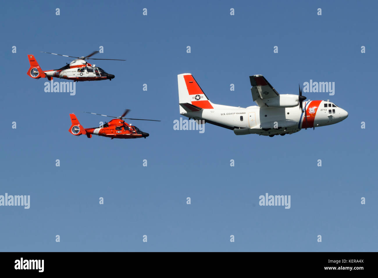 Ein paar der Küstenwache MH-65 Dolphin Helikopter der Air Station San Francisco fliegen in enger Formation mit einem C-27 J Spartan von Air Station Sacramento Stockfoto